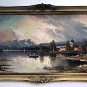 Gerahmtes Gemälde eines ruhigen Sees mit einem Ruderboot, fernen Bergen, Bäumen und einer Kirche am Ufer unter einem dramatischen, wolkenverhangenen Himmel. Der Rahmen ist verschnörkelt und goldfarben.