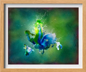 Abstraktes Kunstwerk mit blauen, grünen und weißen Farbspritzern, die sich auf einem strukturierten grünen Hintergrund vermischen und verwirbeln, gerahmt in einem hellen Holzrahmen. Die Formen bilden eine energiegeladene, dynamische Komposition.