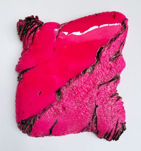 Abstrakte, strukturierte Wandskulptur mit leuchtend pinker, glänzender und aufgerauter Oberfläche mit dunklen, gezackten Kanten, die eine kühne, organische Form vor einem schlichten weißen Hintergrund bilden.