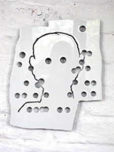 Ein weißes rechteckiges Blatt mit verstreuten kreisförmigen Löchern und einem dünnen schwarzen Umriss eines menschlichen Kopfes und Schultern, montiert auf einer weißen Ziegelwand.