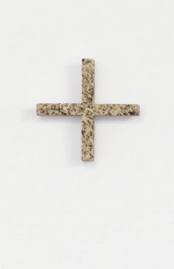 Ein steinernes Pluszeichen mit einer strukturierten, gesprenkelten Oberfläche steht mittig auf einem schlichten weißen Hintergrund.