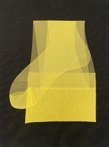 Ein Stück durchsichtiger gelber Stoff liegt ordentlich gefaltet auf einer dunklen, strukturierten Oberfläche, wobei eine Ecke locker zur Seite fällt.