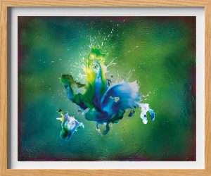 Abstraktes Gemälde mit blauen, grünen und weißen Farbspritzern auf einem strukturierten grünen Hintergrund, gerahmt mit hellem Holz. Die Farbe bildet dynamische, fließende Formen in der Mitte, die energisch nach außen ausstrahlen.