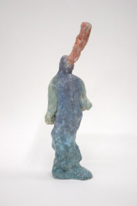 Eine Keramikskulptur einer blauen Figur mit einem hohen, rosa Vorsprung, der aus ihrem Kopf herausragt.