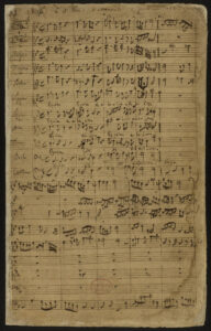 Eine handgeschriebene Partitur auf gealtertem Pergamentpapier mit dem Titel Missa, die mehrere Notenzeilen für Stimmen und Instrumente enthält.